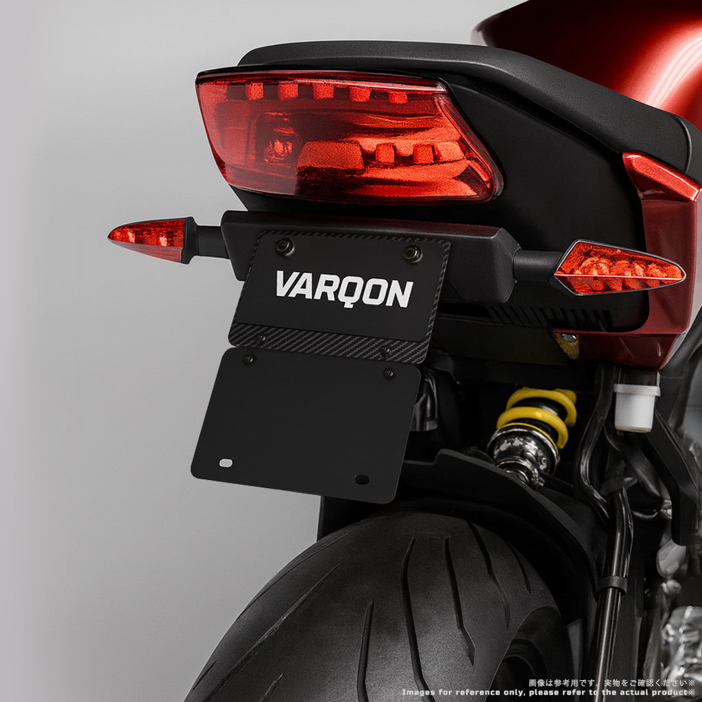 125cc以下対応・山型サイズ｜VARQON カーボン製ナンバープレートフレーム＆マッドガードを装着したバイクのリア斜め画像。軽量・高剛性で原付二種の泥はねを抑えるアクセサリー。
