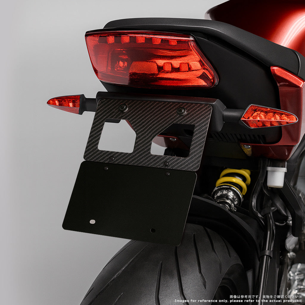 プレート未装着状態の VARQON カーボン製ナンバープレートフレームのクローズアップ。軽量カーボンと開口設計で取り付けやすく、マッドガードと併用可能。